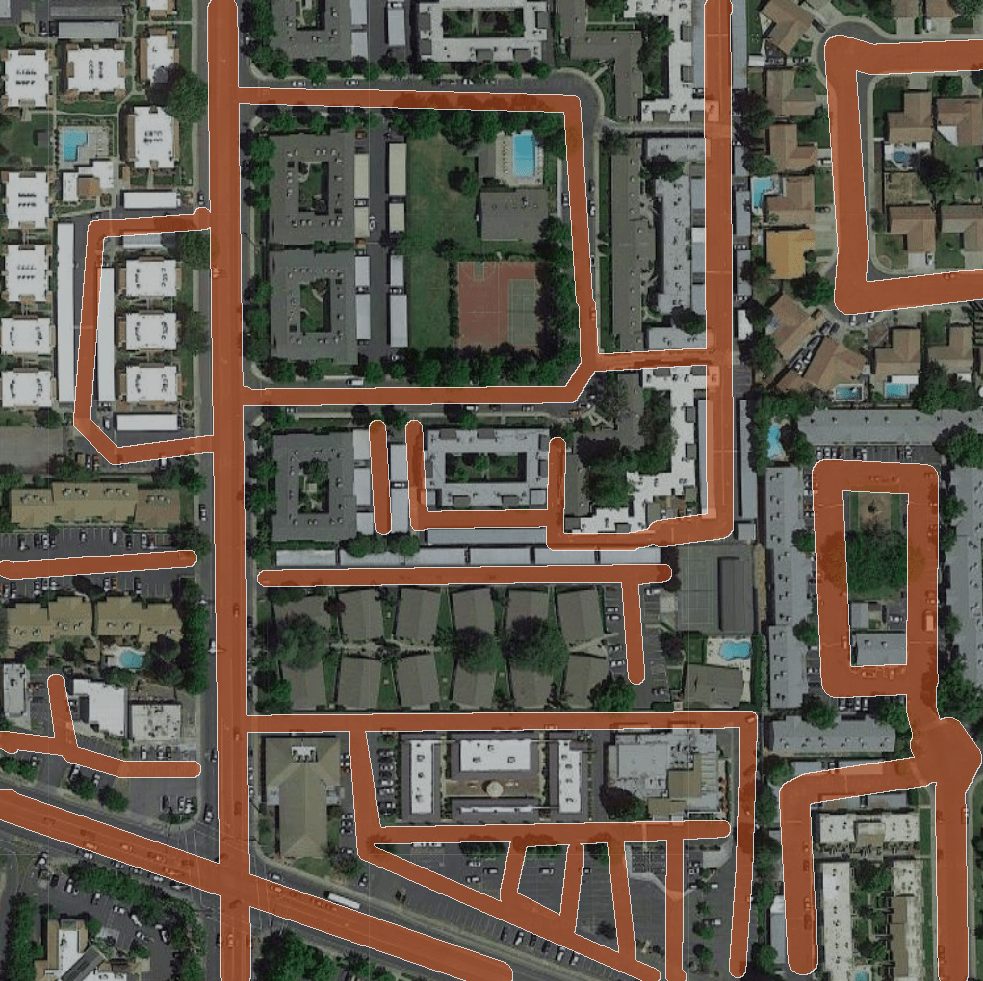 Aerial view of residential neighborhood with orange lines highlighting various pathways or roads, indicating areas designated for road maintenance.