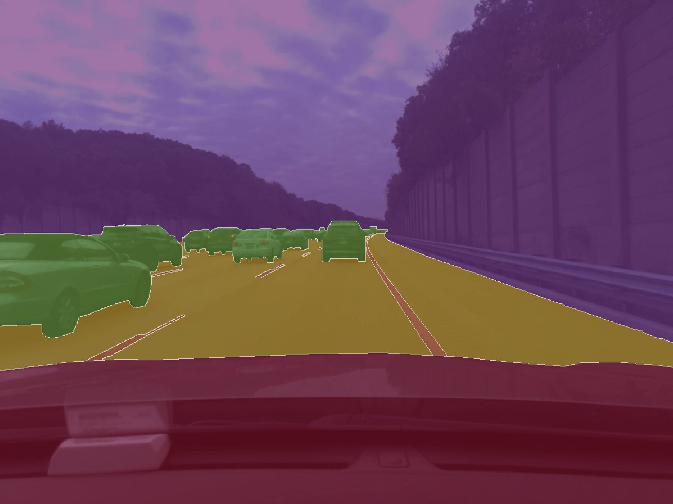 A highway view from inside a car, with identified cars and road areas outlined and highlighted in different colors, using comma10k technology.