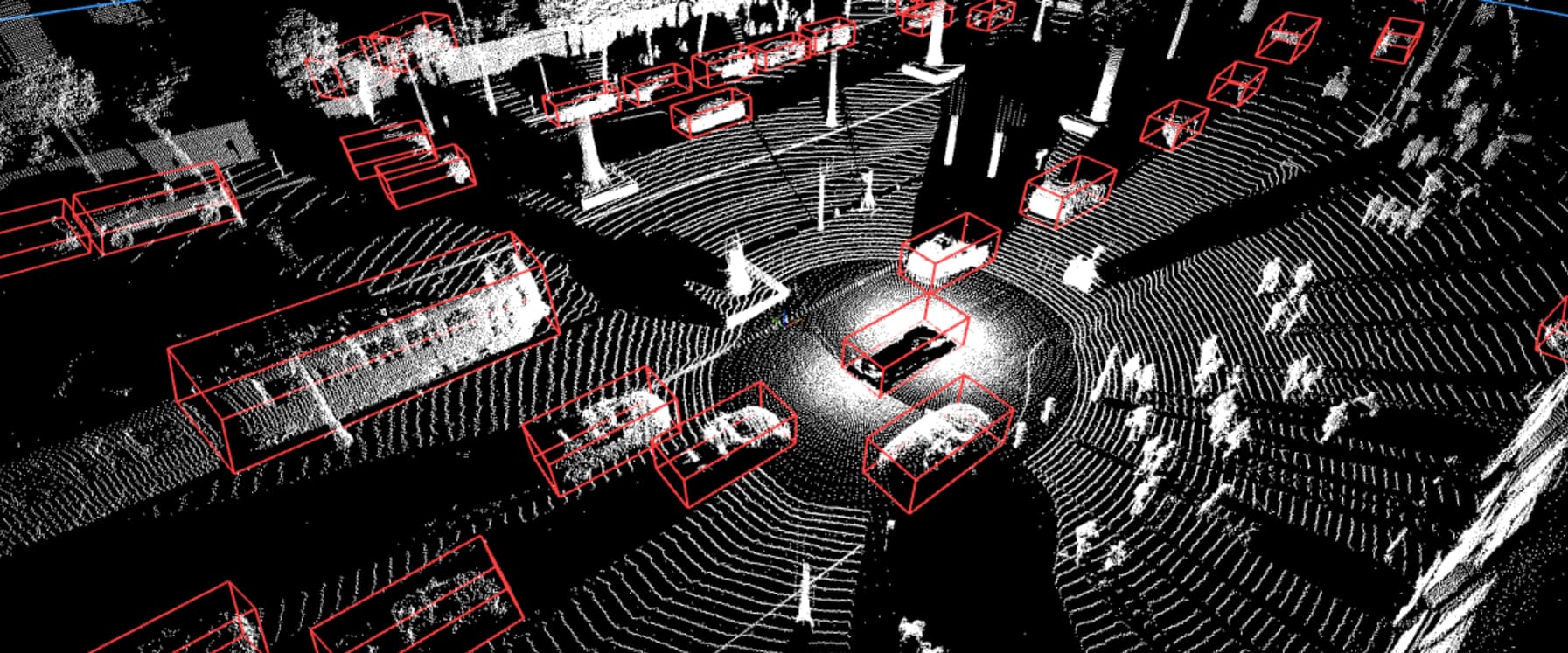 Aerial view of LiDAR technology identifying vehicles and objects on a street in motion, highlighted with red boxes.