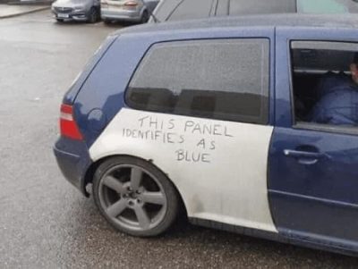 A blue car with a white panel, on which is written "this panel identifies as blue".